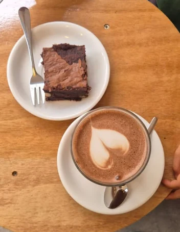 Un brownie et un chocolat chaud avec un cœur dans la mousse