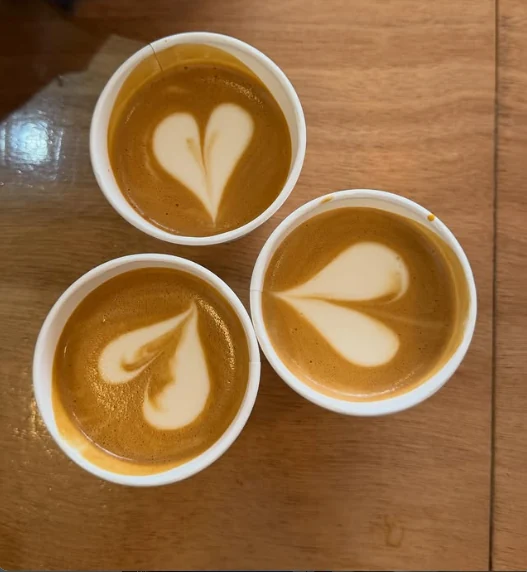Trois cappuccinos vus de dessus, chacun avec un cœur dessiné dans le lait